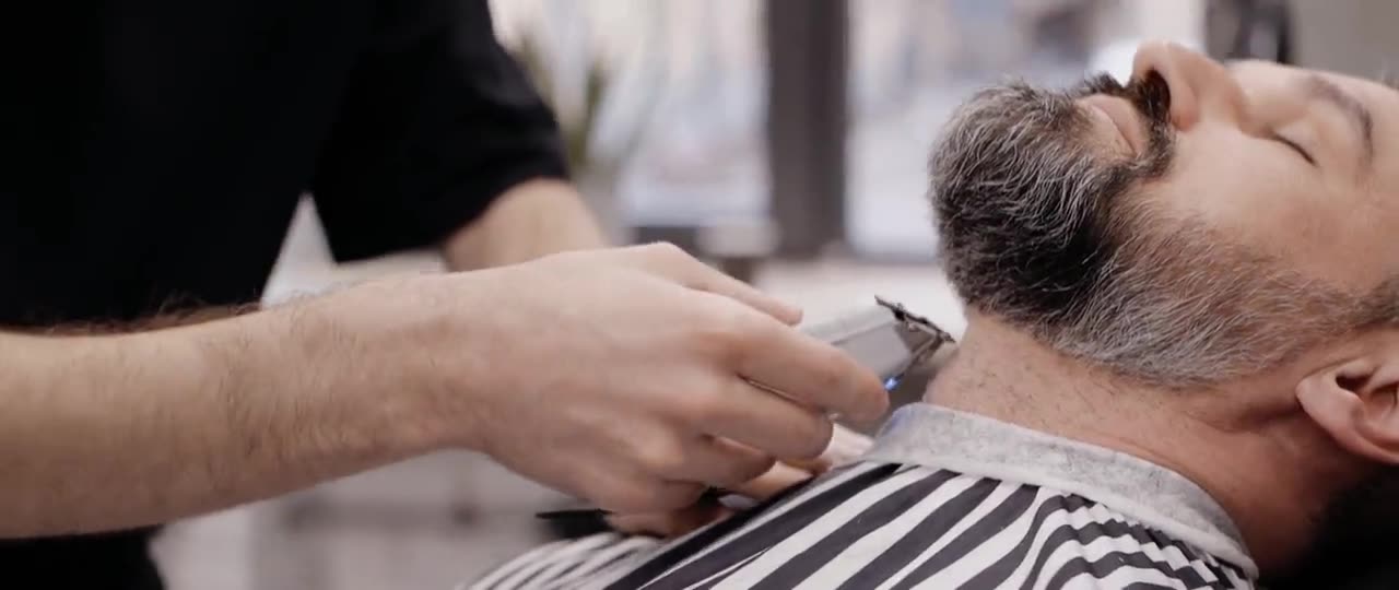 Barber przycinający brodę maszynką